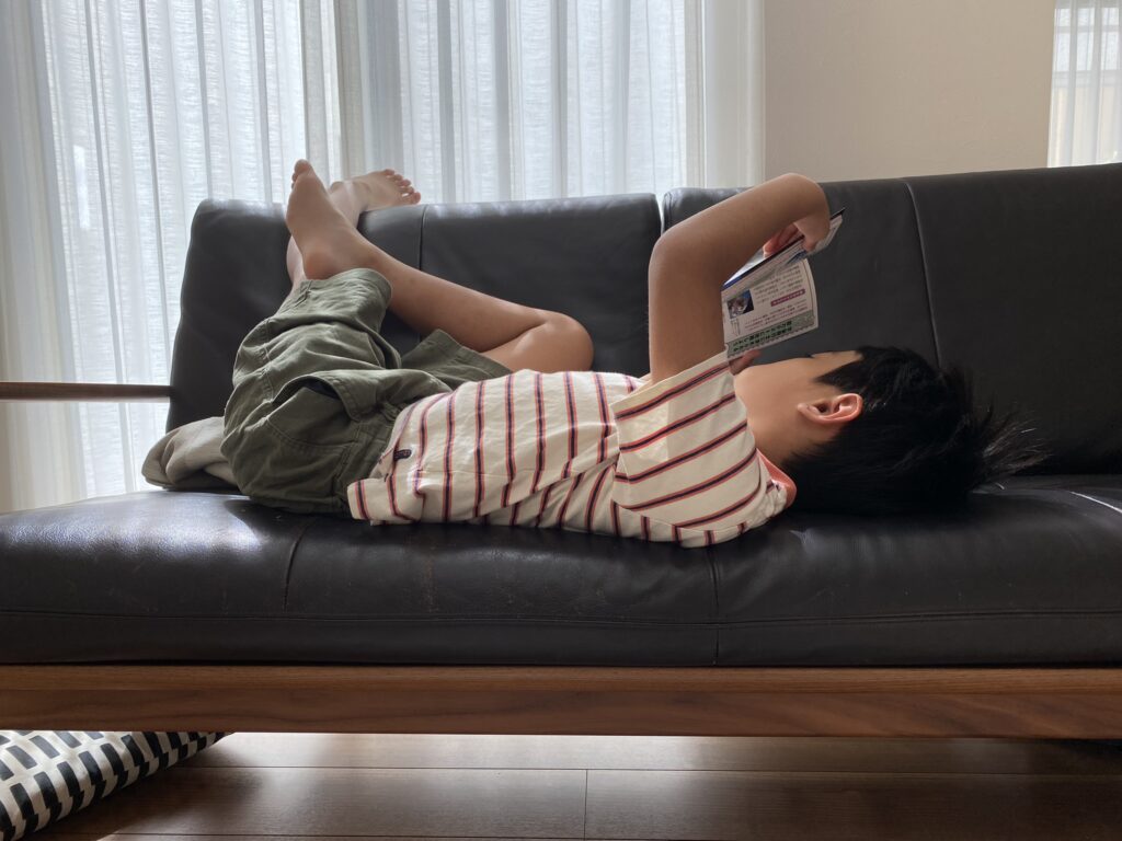寝転んで本を読む息子